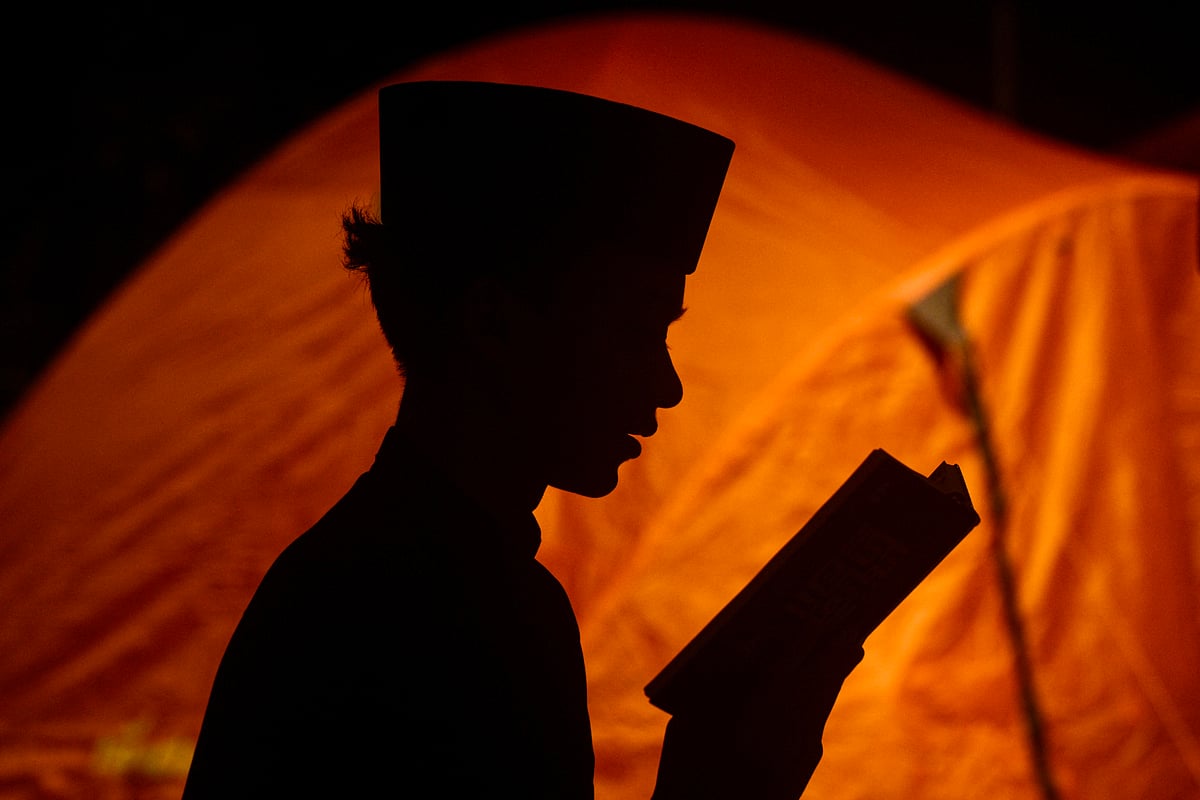 A Muslim boy reads the holy Koran while performing 'itikaf', an Islamic practice carried out by staying in the mosque for a number of days to stay away from worldly affairs.