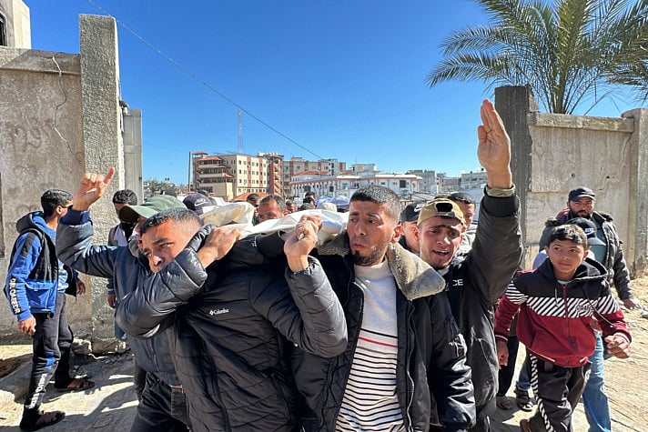 Palestinians carry the body of a relative, killed in Israeli strikes, during their funeral in Khan Yunis in the southern Gaza Strip on March 23, 2025.  