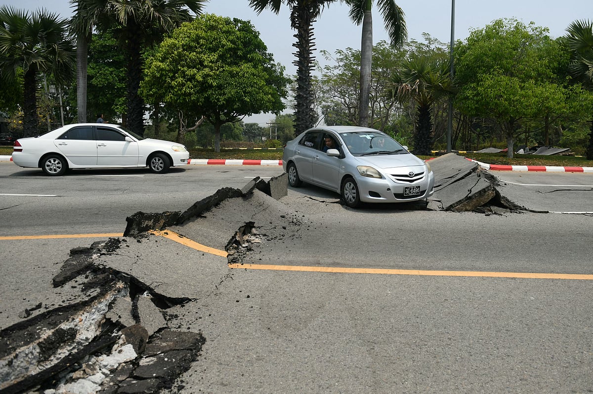 Cars pass a damaged road in Naypyidaw on March 28, 2025, after an earthquake in central Myanmar.