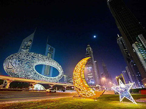 Motorists drive past roadside decorations installed near the Museum of the Future in Dubai. 