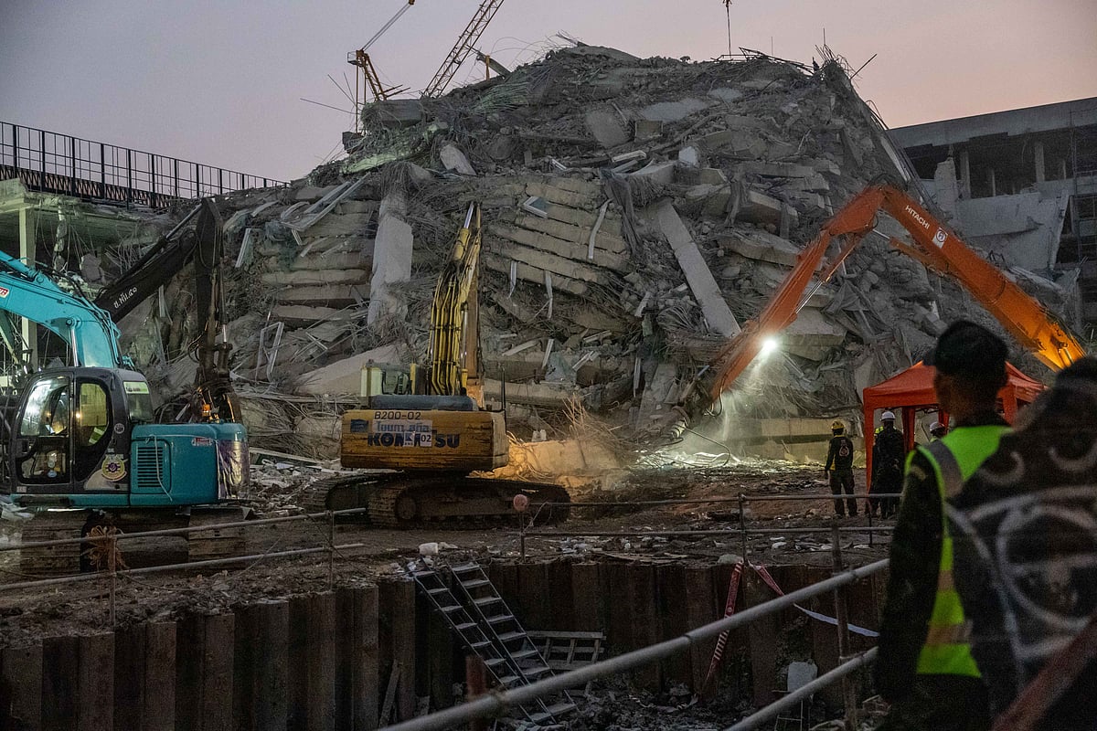 Thai rescue workers search for survivors into the night in the rubble of a building that collapsed following an earthquake in Bangkok on March 29.