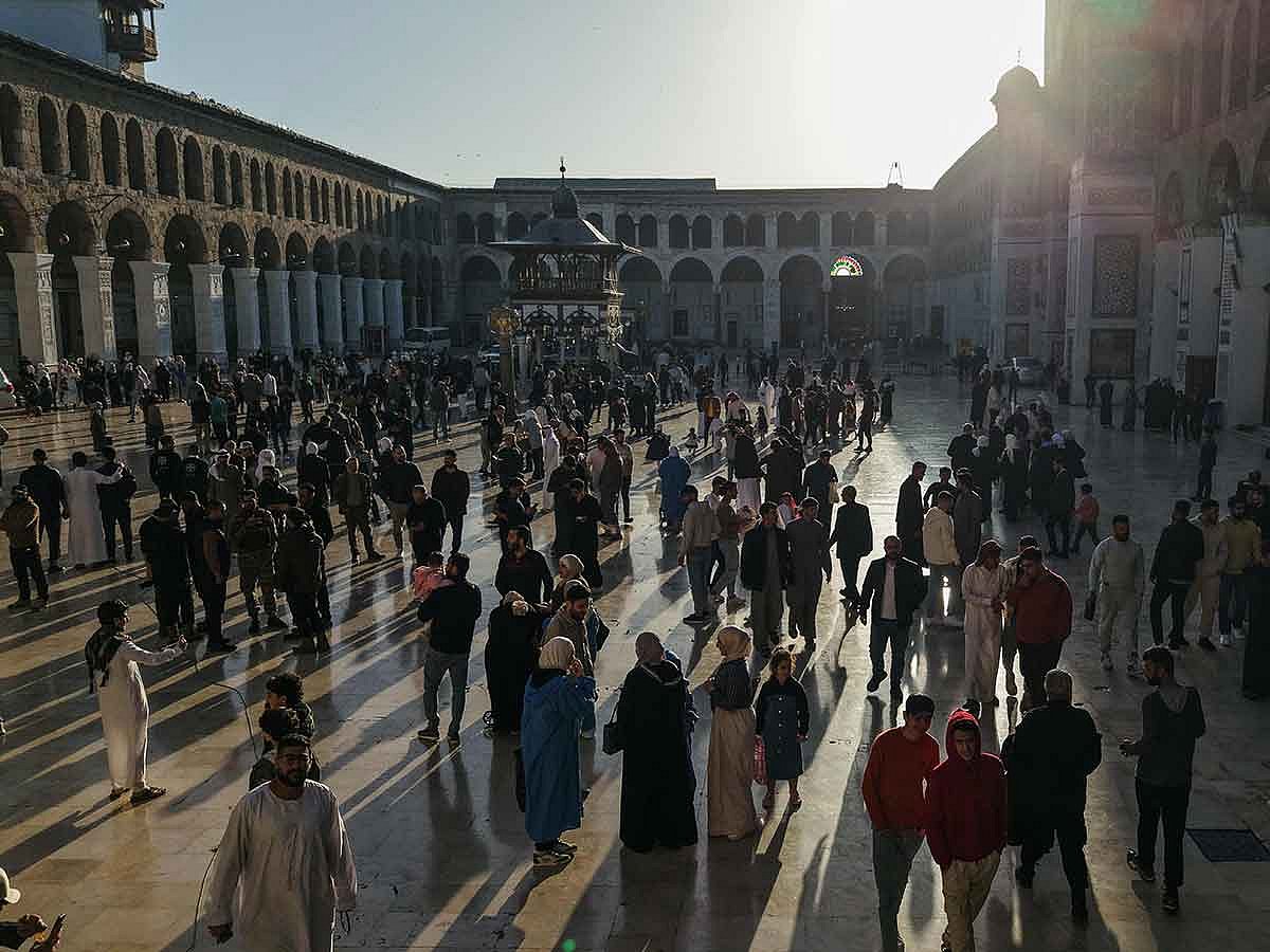 An aerial picture shows people gathering in the Umayyad Mosque courtyard after the morning prayer on the first day of Eid Al Fitr, in Damascus on  March 31, 2025.
