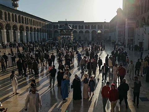 An aerial picture shows people gathering in the Umayyad Mosque courtyard after the morning prayer on the first day of Eid Al Fitr, in Damascus on  March 31, 2025.