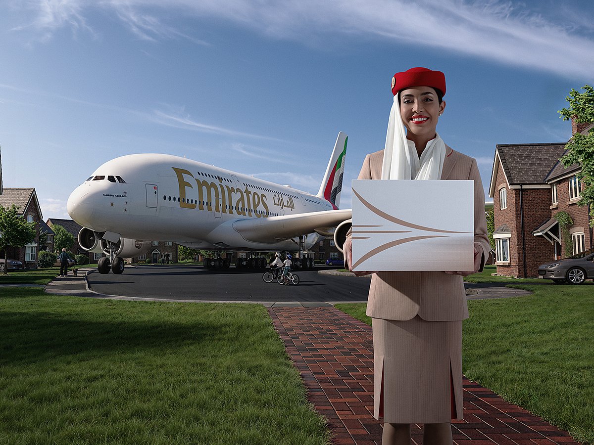 The image shared with the post depicted an Emirates Airline cabin crew member standing in a suburban neighborhood, holding a delivery box. There's an Airbus A380 double decker parked in the driveway as well. 