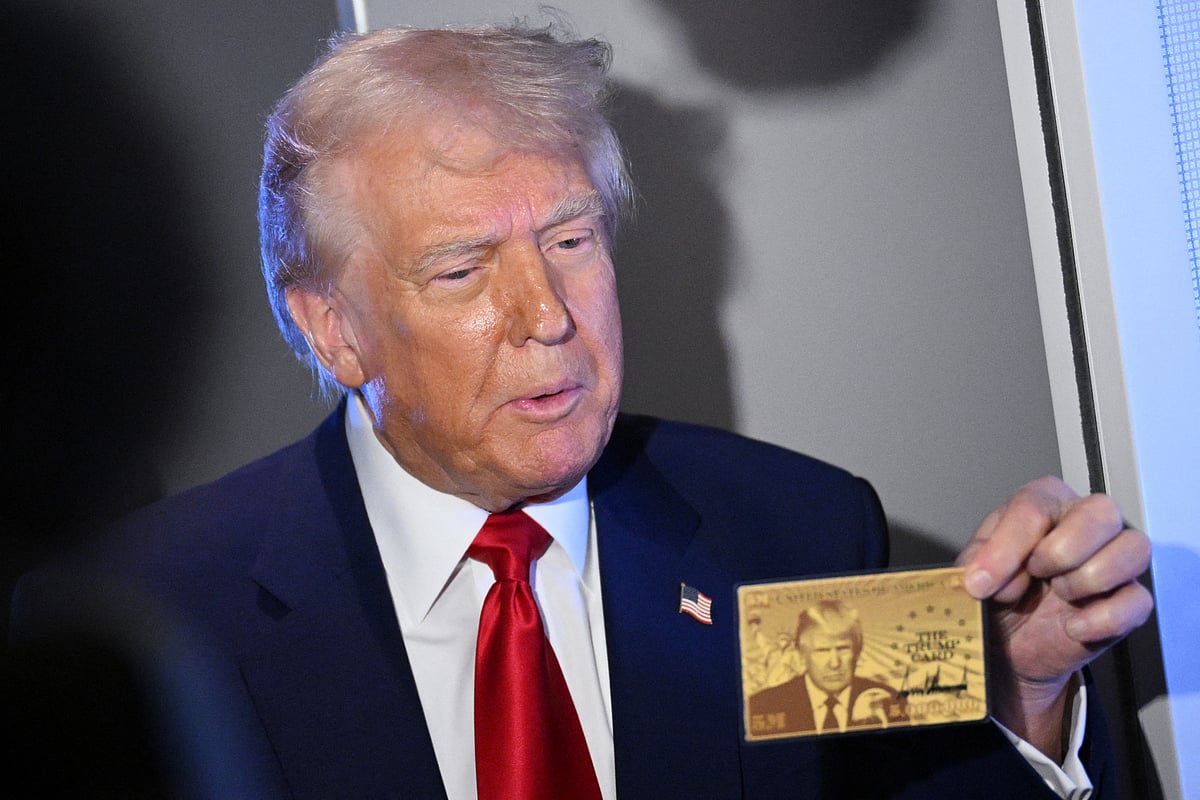 US President Donald Trump holds the $5 million dollar Gold Card as he speaks to reporters while in flight on board Air Force One, en route to Miami, Florida on April 3, 2025.