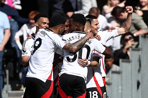 Fulham's Nigerian midfielder Alex Iwobi (C) celebrates with teammates after scoring their second goal during the English Premier League football match against Liverpool at Craven Cottage in London on April 6.