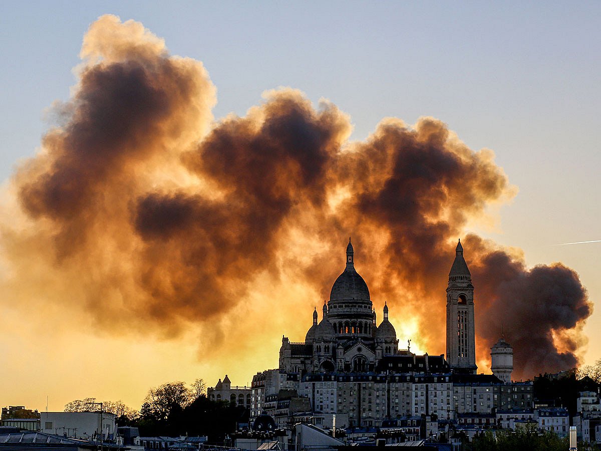 Smoke billows behind the Sacre Coeur Basilica as a "major fire" broke out in the nearby 17th arrondissement, in the north of Paris.