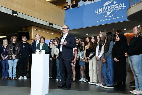 Britain's Prime Minister Keir Starmer delivers a speech as Britain's Chancellor of the Exchequer Rachel Reeves (rear) reacts during his announcement that US media giant Comcast Corp will build its first Universal theme park and resort in Europe, opening in 2031, during a visit to Bedford, north of London, on April 9, 2025.
