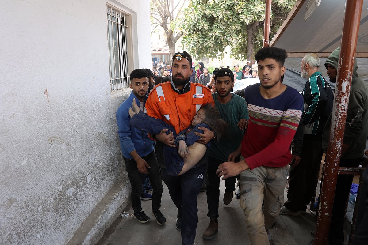 A Palestinian rescuer carries the body of a child killed in an Israeli strike on a residential area in Gaza City's Shujaiyya neighbourhood.