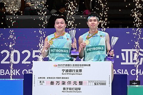 Gold medallists Malaysia's Soh Wooi Yik (R) and Aaron Chia pose with their trophies during the award ceremony for men's doubles final match at the Badminton Asia Championships in Ningbo, in China's eastern Zhejiang Province on April 13.
