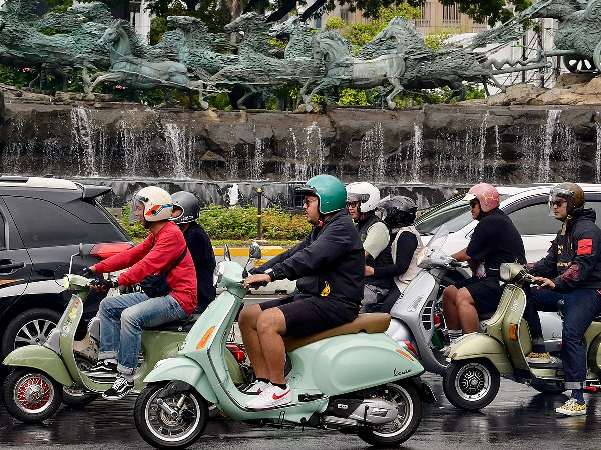 Vespa enthusiasts riding along a road in Jakarta.