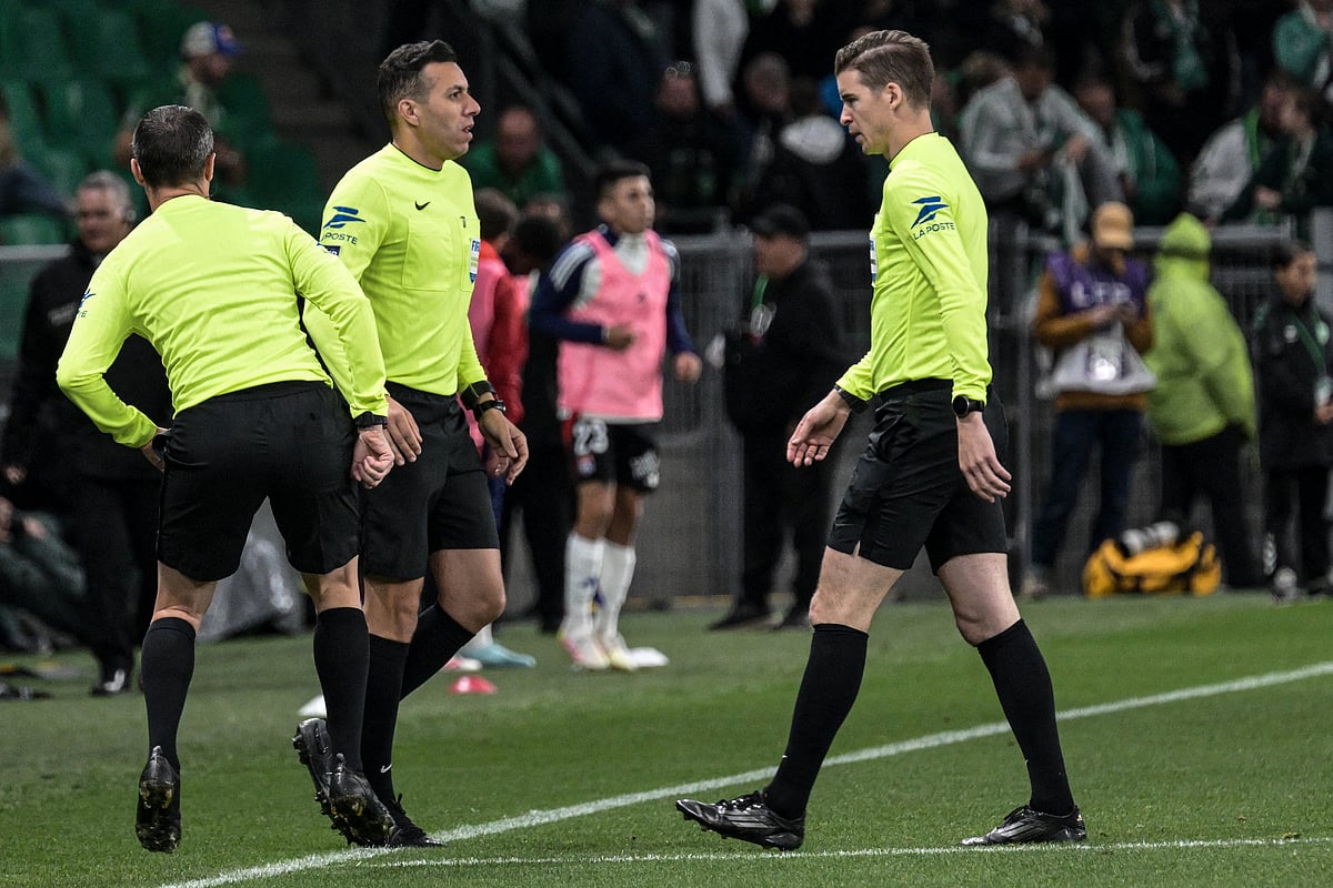 French referee Mehdi Rahmoun (centre) looks on during the French L1 football match between AS Saint-Etienne and Olympique Lyonnais after the match was suspended at the Geoffroy-Guichard Stadium in Saint-Etienne, central France on April 20.