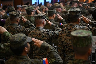 Philippine soldiers salute as the national anthem is played at camp Aguinaldo in Manila. File photo taken on April 21, 2025.