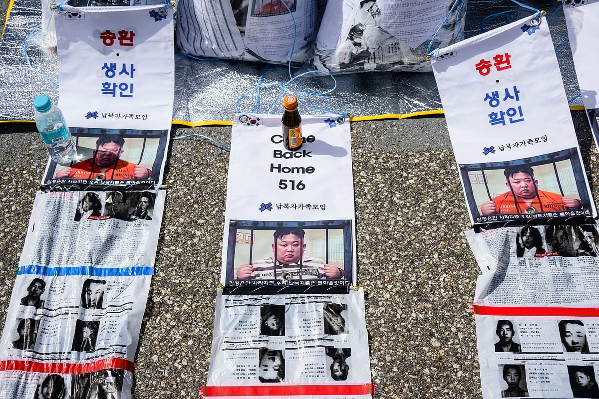 Pictures depicting North Korean leader Kim Jong Un are seen with anti-North Korea propaganda leaflets attached to bags at the Imjingak Pavilion near the Demilitarized Zone (DMZ) dividing the two Koreas in Paju, north of Seoul on April 23, 2025, as members of the Association of the Families of Those Abducted by North Korea prepare to send them across the border.
