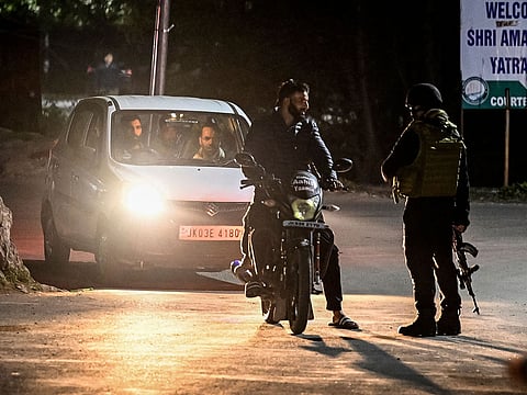 An Indian Army personnel stops vehicles for inspection near Pahalgam, south of Srinagar, following an attack.