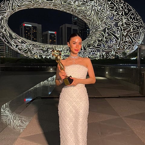Heart poses with her trophy from EMI Gala against the backdrop of the Museum of the Future in Dubai.