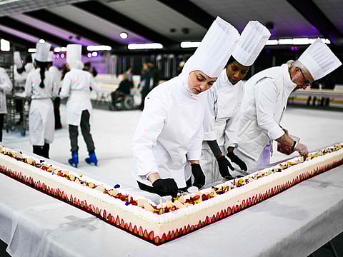 Pastry chefs work on the world's largest strawberry cake.