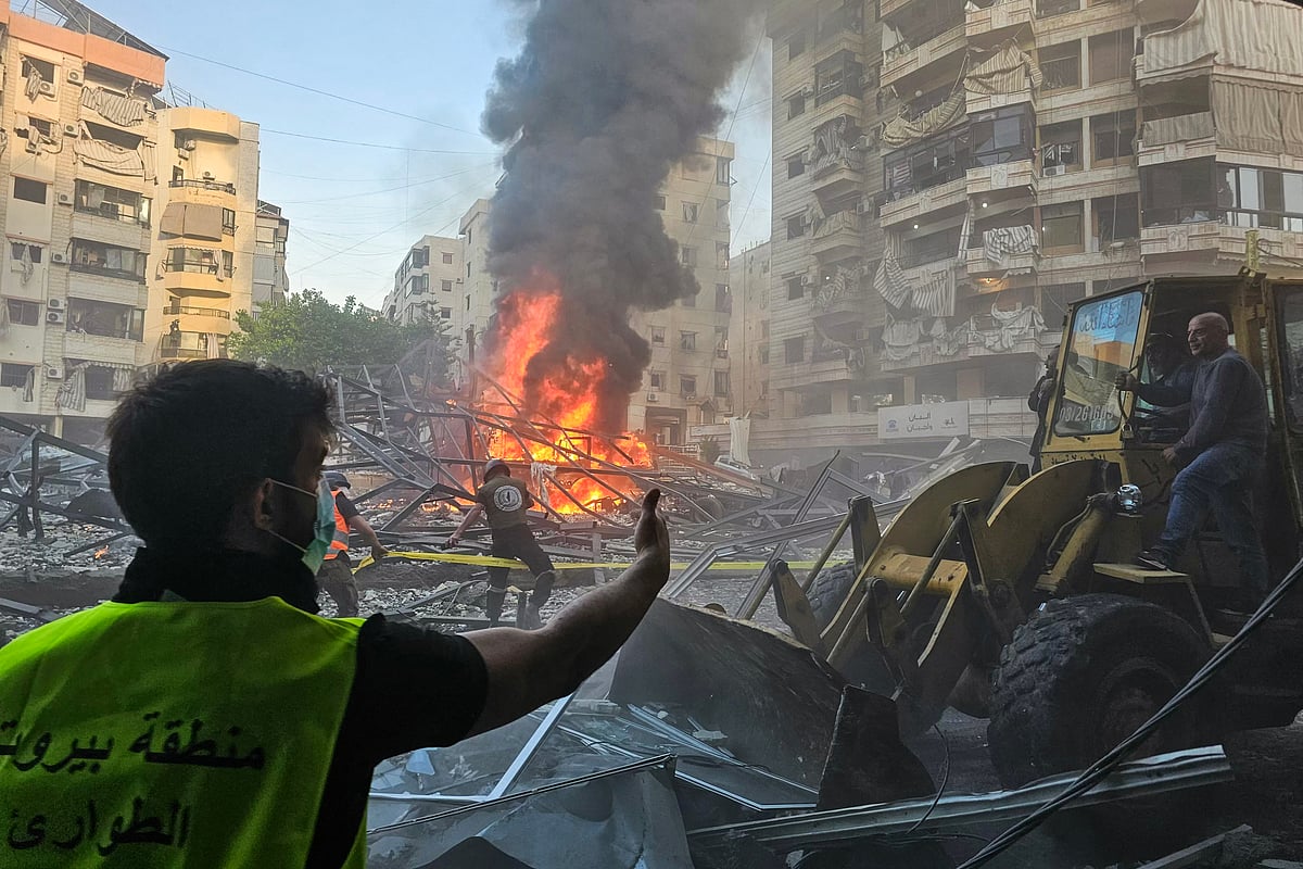 Lebanese emergency teams cordon off the perimeter of a fire at the site of Israeli strikes following evacuation orders, in Beirut's southern suburb on April 27, 2025.