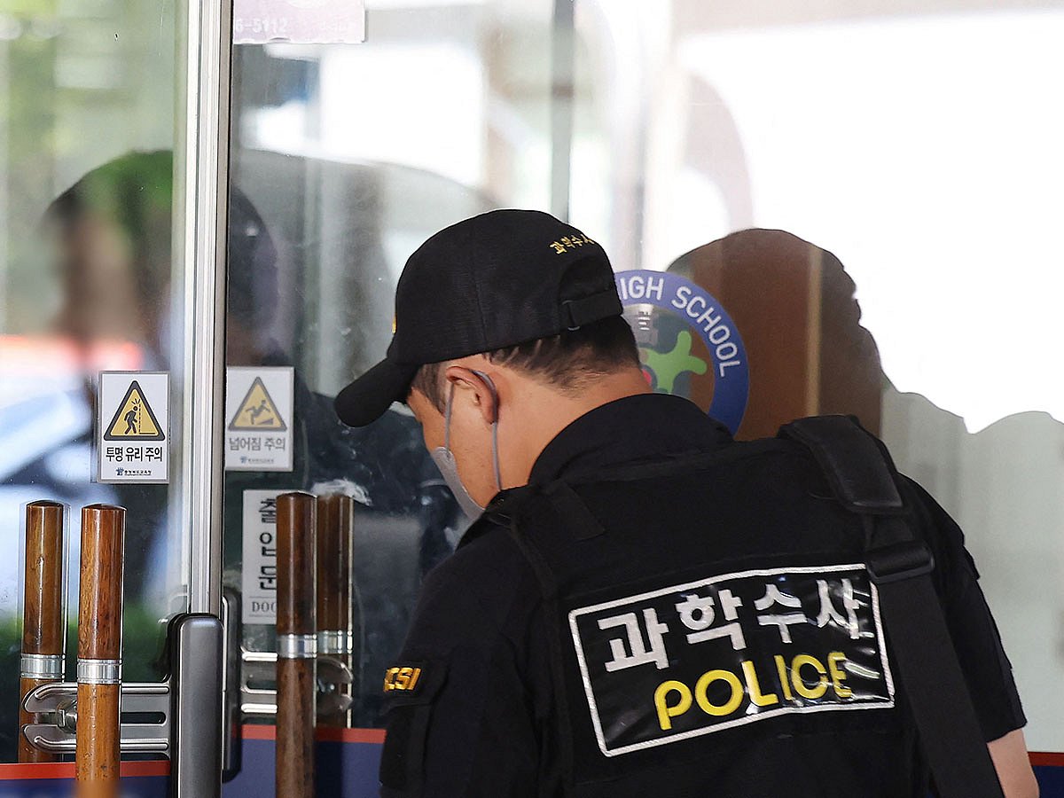 Members of South Korean Police Crime Scene Investigation team probe at a high school in Cheongju after a knife attack by a student.