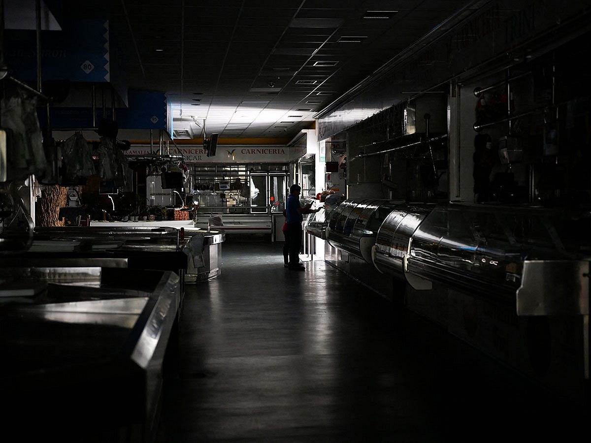 A man and a child walk through a local market during a massive power cut in Vigo, northwestern Spain, on April 28, 2025.  