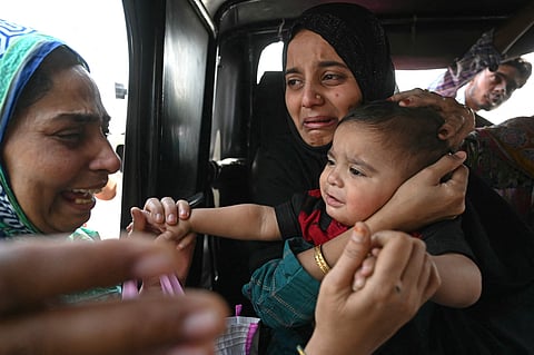 A Pakistani citizen (C) bids goodbye to her son, an Indian citizen, as she prepares to return to her country through the India-Pakistan Wagah border post, about 35 km from Amritsar, on April 29, 2025. The departure of Pakistani nationals from India through the Attari Border saw a significant rise on Tuesday, April 29, coinciding with the last day of validity for medical visas issued to them as per the Indian government's decision.