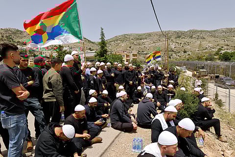 Druze men demonstrate in solidarity with the Syrian Druze community near the border barrier in the village of Majdal Shams in the Israeli-annexed Golan Heights on April 30, 2025.
