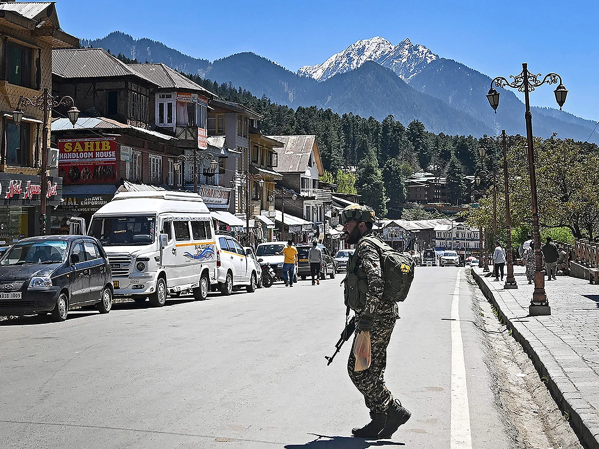An Indian paramilitary trooper patrols at a market area in Pahalgam south of Srinagar on April 29, 2025. 