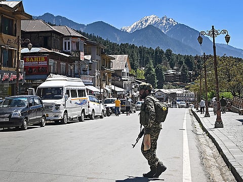 An Indian paramilitary trooper patrols at a market area in Pahalgam south of Srinagar on April 29, 2025. 