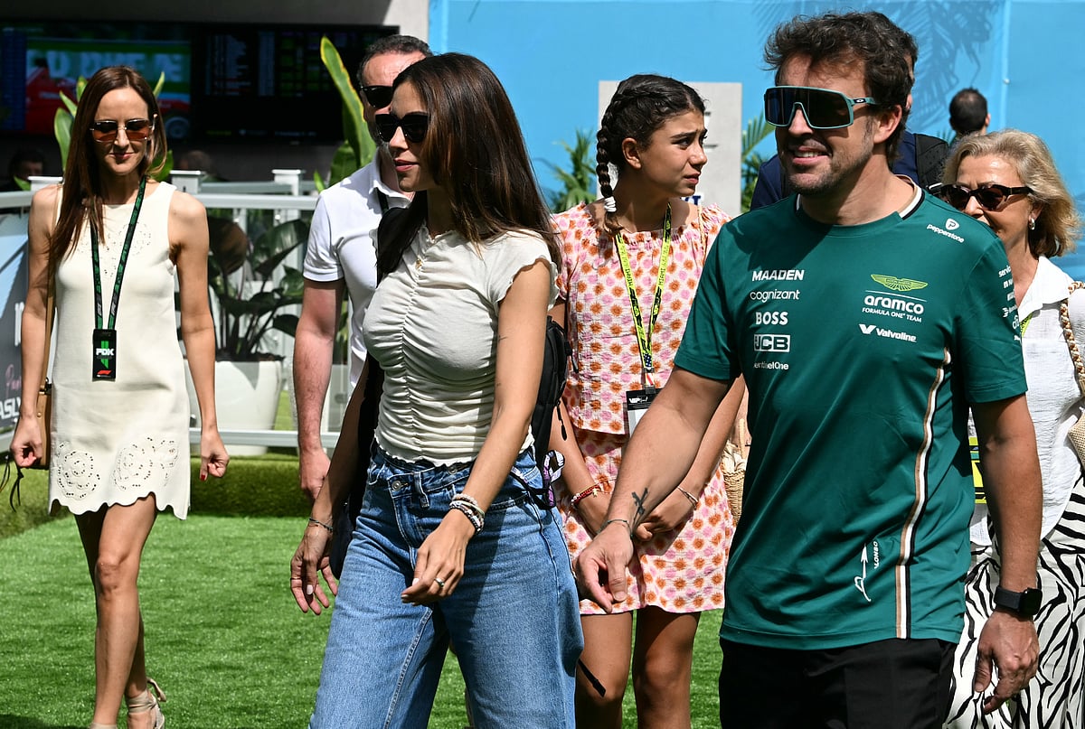 Aston Martin's Spanish driver Fernando Alonso (R) arrives with partner journalist Melissa Jiménez (3rd R) ahead of a practice session for the 2025 Miami Formula One Grand Prix at Miami International Autodrome in Miami Gardens, Florida, on May 2, 2025.