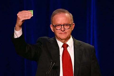 Australia's Prime Minister Anthony Albanese holds his Medicare card as he speaks after winning the general election at the Labour Party election night event in Sydney on May 3, 2025.