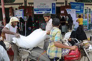 Displaced Yemenis load bags of food and supplies to meet their basic needs on their motorcycle in the western province of Hodeida on May 4, 2025.