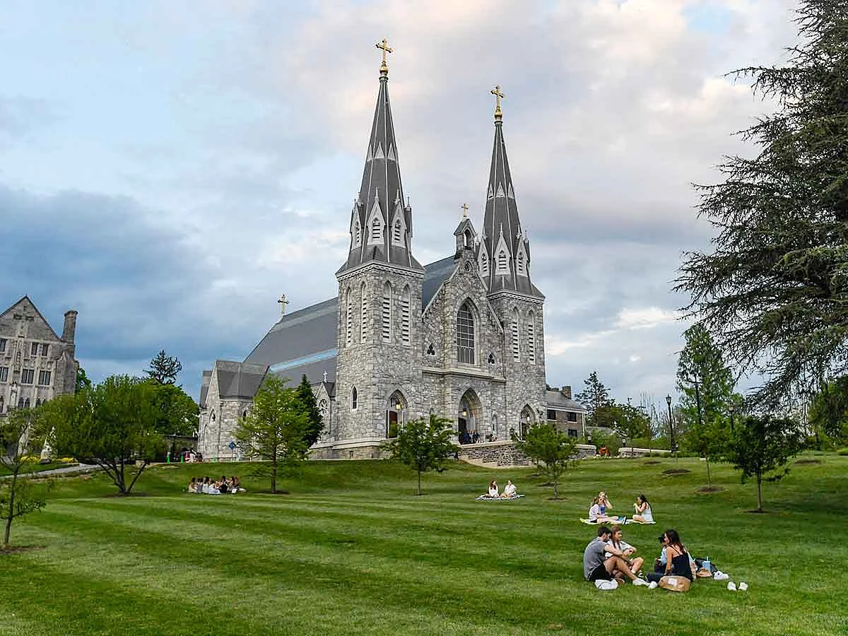 Students sit on the lawn outside of St. Thomas of Villanova Church at the campus of Villanova University in Villanova, Pennsylvania. 