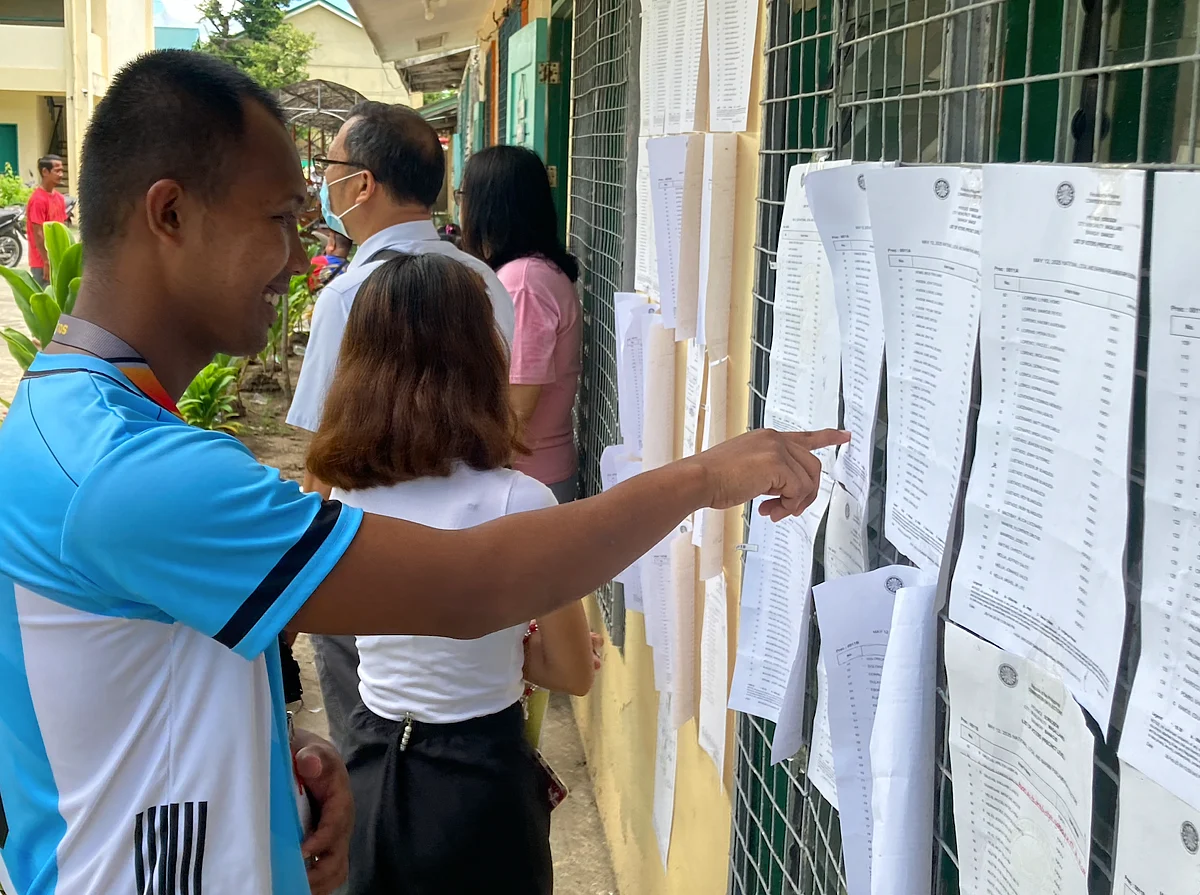 ROLL CALL FOR DEMOCRACY: A Filipino voter scans the voters’ list outside a polling booth on Monday, May 12, 2025, as the midterm election buzz kicks off nationwide. With 94,000 precincts on the map and 11,000 extra vote-counting machines on standby, the Philippines is all set for another epic day of people power. 
