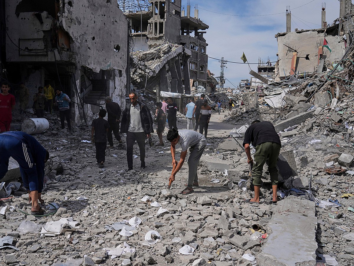 Palestinians clean the rubble along a road beside a clinic destroyed by Israeli airstrikes in Jabalia, in the northern Gaza Strip, on Thursday, May 15, 2025.