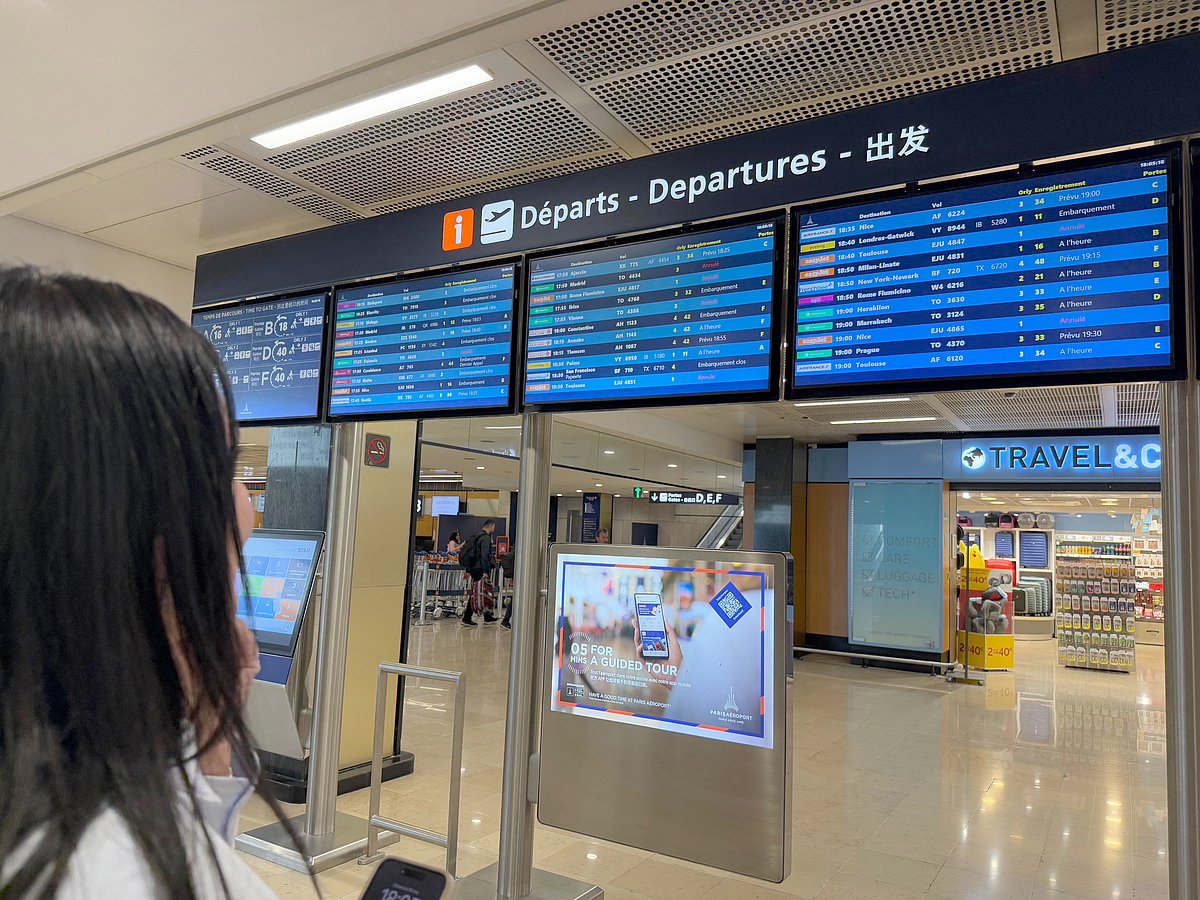 A traveller looks at flights informations boards during a breakdown in air traffic control systems at Paris-Orly airport in Orly, South of Paris, on May 18, 2025.