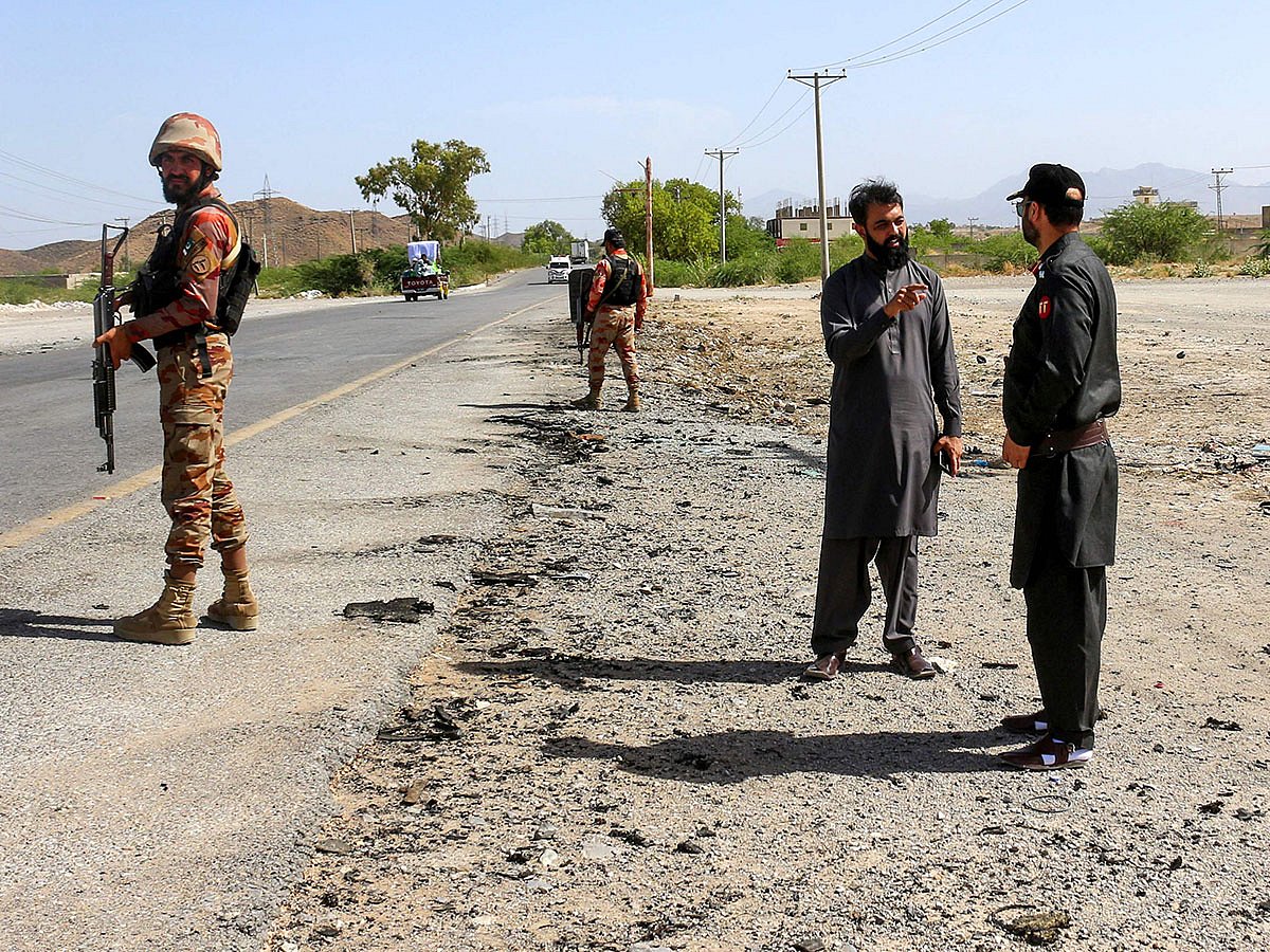Security personnel stand guard at the site of a school bus bombing in Khuzdar district of Balochistan province on May 21, 2025.  