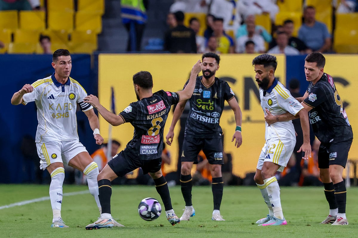 Nassr's Portuguese forward Cristiano Ronaldo vies for the ball with Khaleej's Saudi midfielder  Khaled al-Samiri during the Saudi Pro League football match between Al-Nassr and Al-Khaleej at Al-Awwal Park in Riyadh on May 21, 2025.