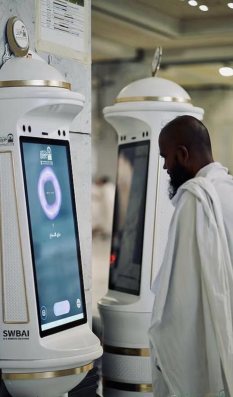 A Muslim worshipper seeks help from the Manara robot in the Grand Mosque in Mecca.  