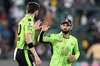 Lahore Qalandars' captain Shaheen Shah Afridi (L) celebrates with Sikandar Raza after taking the wicket of Quetta Gladiators' Hasan Nawaz during the Pakistan Super League (PSL) Twenty20 final cricket match between Lahore Qalandars and Quetta Gladiators at the Gaddafi Stadium in Lahore on May 25, 2025.