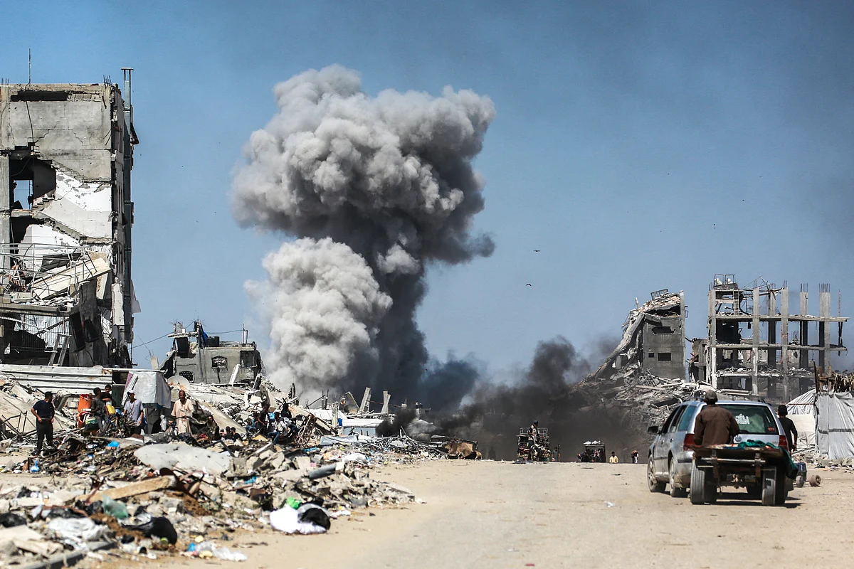 People watch as smoke billows following an Israeli strike in Jabalia, in the northern Gaza Strip on May 25, 2025.