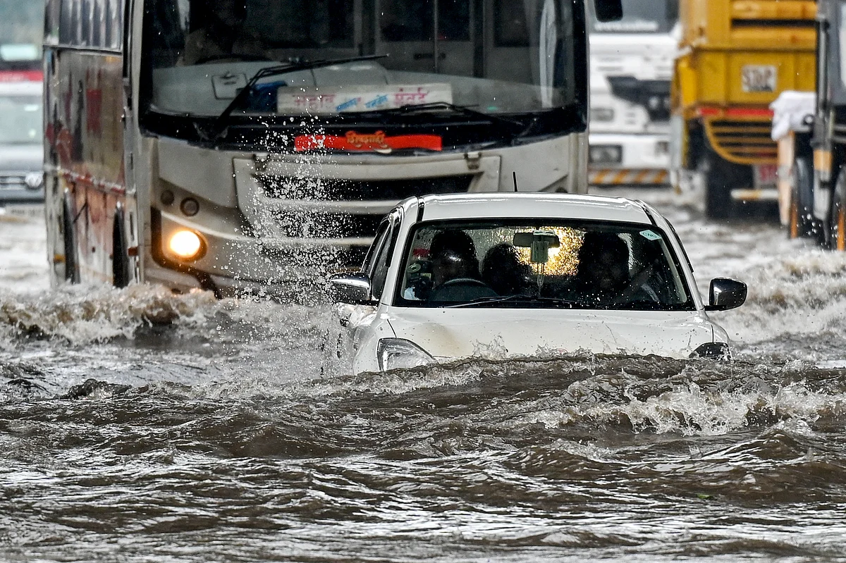 A car lies partially submerged as it wades through a flooded street after heavy rain showers in Mumbai.