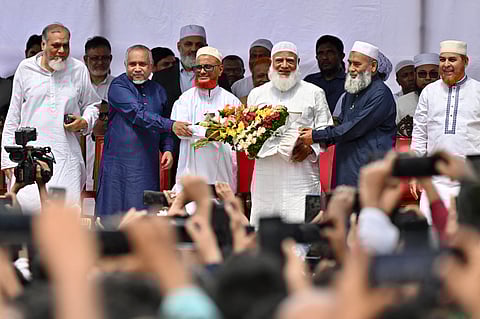 Bangladesh's Jamaat-e-Islami Ameer Shafiqur Rahman presents a floral wreath to leader A.T.M. Azharul Islam after he was released from prison in Dhaka on May 28, 2025.