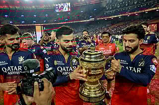Royal Challengers Bengaluru's Virat Kohli (C) and captain Rajat Patidar (R), along with their teammates, take a victory lap around the field as they celebrate with the trophy after winning the Indian Premier League (IPL) Twenty20 final cricket match against Punjab Kings at the Narendra Modi Stadium in Ahmedabad on June 4, 2025.