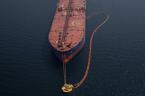 Pipes feed crude oil to a tanker.