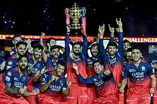 Royal Challengers Bengaluru's Virat Kohli (C), along with his teammates, celebrates with the trophy after winning the Indian Premier League (IPL) Twenty20 final match against Punjab Kings at the Narendra Modi Stadium in Ahmedabad on June 4, 2025.