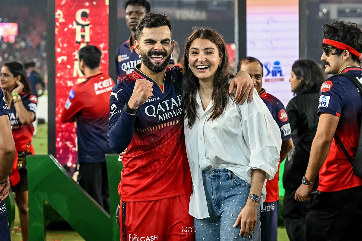 Royal Challengers Bengaluru's Virat Kohli (centre L) celebrates along with his wife and actress Anushka Sharma (centre R) after winning the Indian Premier League (IPL) Twenty20 final cricket match against Punjab Kings