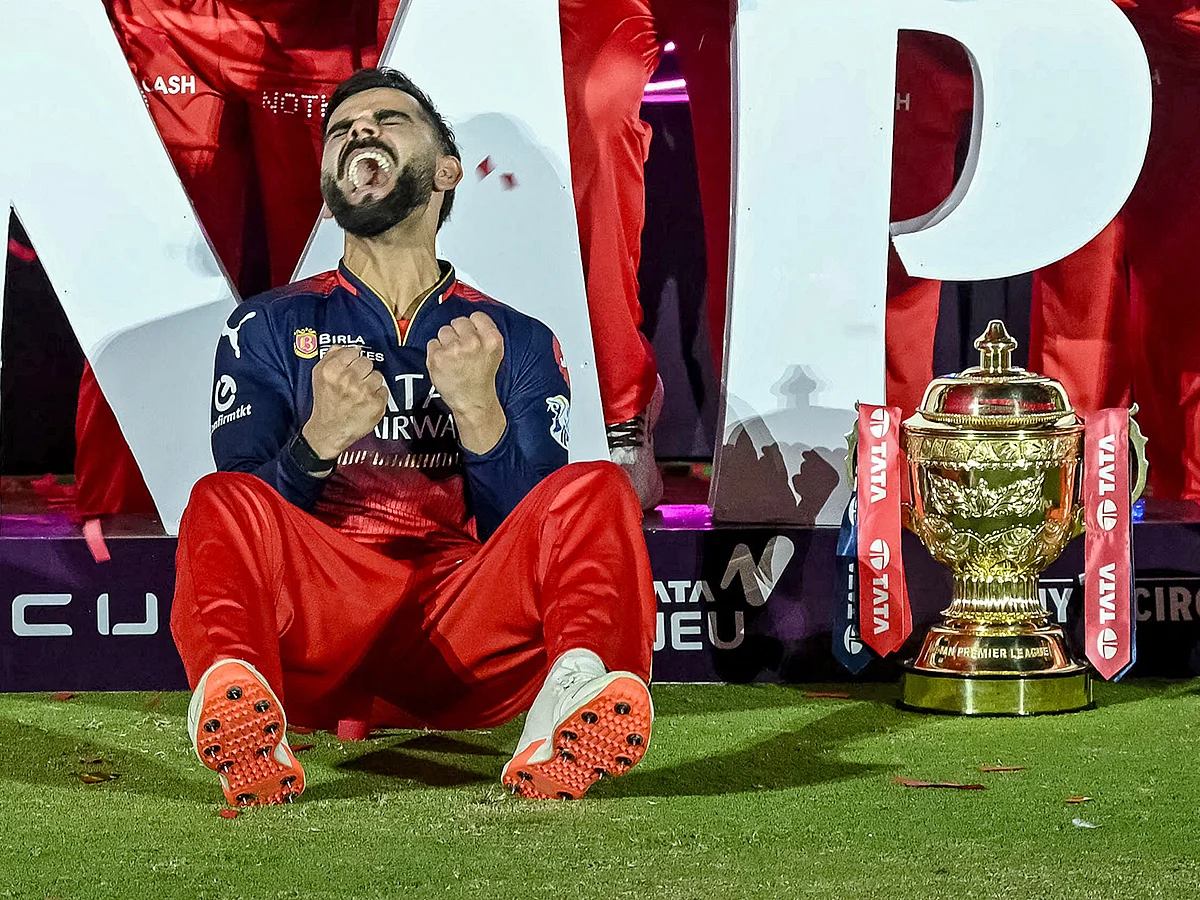 Royal Challengers Bengaluru's Virat Kohli reacts while sitting beside the trophy after winning the Indian Premier League (IPL) Twenty20 final cricket match against Punjab Kings at the Narendra Modi Stadium in Ahmedabad on June 4, 2025. 