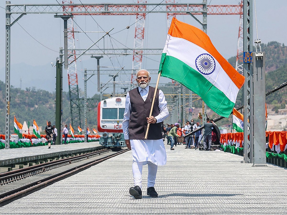 India's Prime Minister Narendra Modi holding national flag during the inauguration of the Chenab Rail Bridge as a part of the Kashmir rail link, in Reasi, in Jammu and Kashmir. 