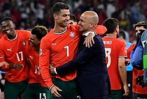 Portugal's forward #07 Cristiano Ronaldo and Portugal's Spanish head coach Roberto Martinez celebrate winning the UEFA Nations League final football match between Portugal and Spain in Munich, southern Germany on June 8, 2025.