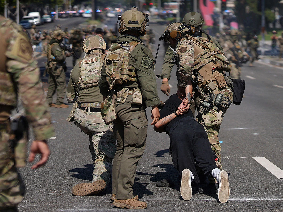 Police detain a man during a protest in the Paramount section of Los Angeles, Saturday, June 7, 2025, after federal immigration authorities conducted operations.
